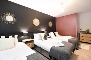 a room with three beds and a black wall at Northern Hideaways, The Nest Ponteland in Newcastle upon Tyne