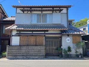 a house with a sign on the front of it at お宿とごはん百々 in Tanabe