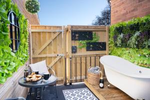a bath tub sitting on a patio next to a fence at Northern Hideaways, The Nest Ponteland in Newcastle upon Tyne
