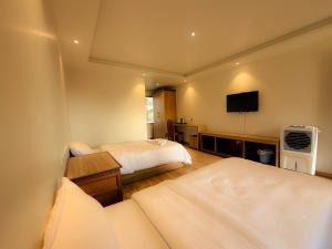 a hotel room with two beds and a flat screen tv at Tharlam Guest House in Kathmandu