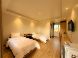 a bedroom with two beds and a flat screen tv at Tharlam Guest House in Kathmandu +7 photos