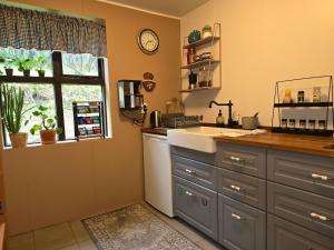 a kitchen with a counter and a sink and a window at Prestshús 2 Guesthouse in Vík