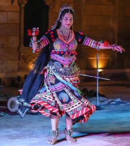 a woman is dancing on the ice in a dress at Desert Popular Resort & Camp in Jaisalmer