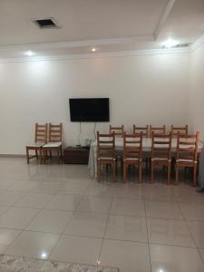 a room with a table and chairs and a flat screen tv at Zayed chalet for families in Al Khīrān +10 photos