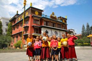a group of children holding soccer balls in front of a building at Tharlam Guest House in Kathmandu