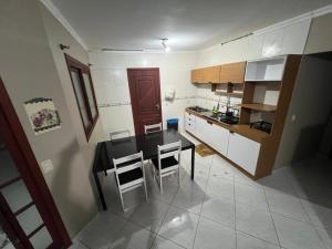 a small kitchen with a table and chairs in it at Medeiros in Capão da Canoa