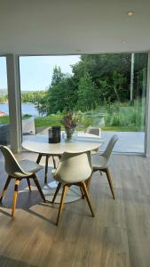 a table and chairs in a room with a large window at Hytte Med Havudsigt Nær Kristiansand in Hamresanden +12 photos