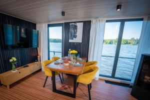ein Esszimmer mit Tisch und Stühlen und einem großen Fenster in der Unterkunft Adventurous Water House Emsel Woma in Fürstenberg-Havel