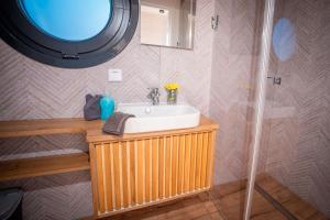 ein Badezimmer mit Waschbecken und Spiegel in der Unterkunft Adventurous Water House Emsel Woma in Fürstenberg-Havel