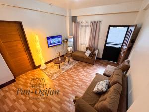 a living room with a couch and a television at Pan-Ogifan Transient in Baguio