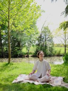 a woman sitting on a blanket in the grass at Gîte de plain-pied sans escaliers, Dordogne in Firbeix +52 photos