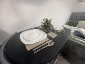 a black table with plates on top of it at Modern Studio - Centre Maidstone in Maidstone
