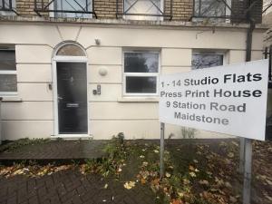 a sign in front of a house with a building at Modern Studio - Centre Maidstone in Maidstone +2 photos