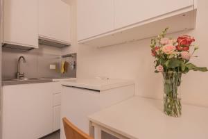 a vase of flowers on a counter in a kitchen at City Center - TinyStudio Piazza San Giacomo in Udine