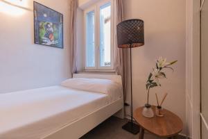 a small bedroom with a white bed and a window at City Center - TinyStudio Piazza San Giacomo in Udine
