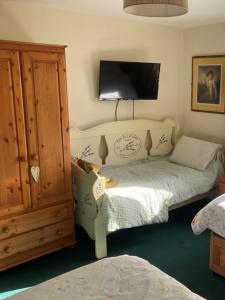ein Schlafzimmer mit einem Bett und einem Fernseher an der Wand in der Unterkunft Brandreth Barn in Burscough