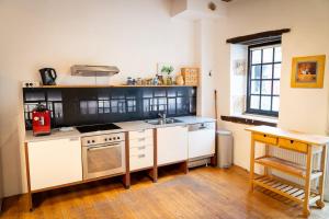 La Celle-sous-GouzonMaison 1的厨房配有白色橱柜、水槽和炉灶