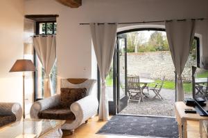 a living room with an open door to a patio at Maison 1 in Souvigny +16 photos