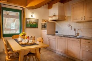 uma cozinha com uma mesa de madeira e uma sala de jantar em Agritur Bontempelli em Pellizzano