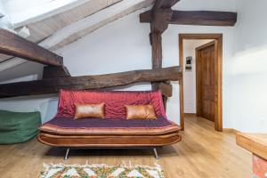 ein rotes Sofa in einem Zimmer mit Holzbalken in der Unterkunft Casa Velarde Apto 1 in Viérnoles
