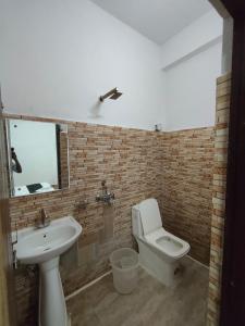 a bathroom with a sink and a toilet and a mirror at RROOMS Hotel Orphic Inn in Lucknow