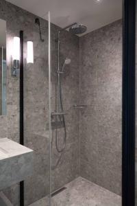 a bathroom with a shower with a glass door at The Dock in Södertälje +21 photos
