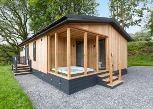a small wooden cabin with a black exterior at Celtic Escapes in Narberth