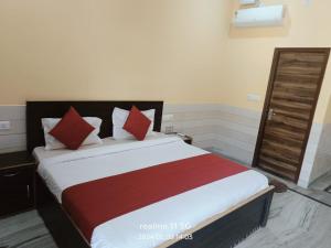 um quarto com uma cama grande com travesseiros vermelhos em Hotel Pyaremohan em Vrindāvan