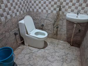 um banheiro com vaso sanitário e pia em Hotel Pyaremohan em Vrindāvan