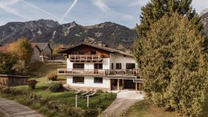 a large white house with mountains in the background at Alpenchalet am Lech in Ehenbichl