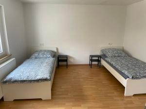 two twin beds in a room with wooden floors at Eigentumswohnung für 5 Personen in Donzdorf