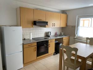 a kitchen with a white refrigerator and a table at Eigentumswohnung für 5 Personen in Donzdorf