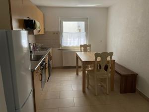 a kitchen with a table and chairs and a refrigerator at Eigentumswohnung für 5 Personen in Donzdorf