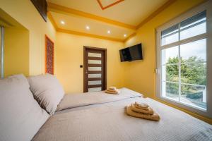 a bedroom with a bed with two towels on it at White House Apartman Miskolc, East Room in Miskolc