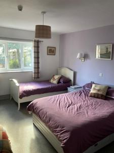 1 Schlafzimmer mit 2 Betten und lila Bettwäsche in der Unterkunft Brandreth Barn in Burscough + 49 Fotos
