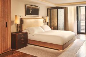 a bedroom with a large bed with a nightstand and lamps at The Connaught, Maybourne in London