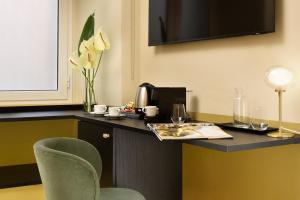 a desk with a chair and a vase of flowers at Velantia Vaticano - Guesthouse in Rome