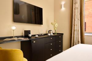 a bedroom with a black dresser with a television on the wall at Velantia Vaticano - Guesthouse in Rome +7 photos