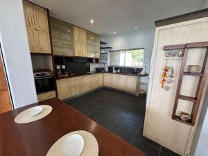 a kitchen with wooden cabinets and a wooden table at 5 Suikerbossie in Gordonʼs Bay