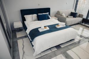 a bedroom with a large bed and a couch at Prestige Luxury Spa Suite- Basen, Jacuzzi, Sauna & Prywatne Miejsce Parkingowe in Lublin