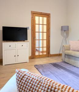 a living room with a television and a couch at Kintyre apartment in Campbeltown