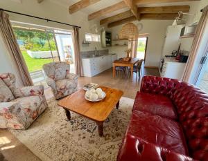 a living room with a red couch and a table at Jonkershuis Farm Retreat in Heidelberg +17 photos