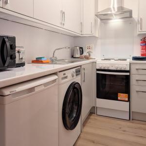 a kitchen with a washing machine and a sink at Kintyre apartment in Campbeltown