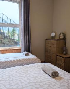 a bedroom with two beds and a window at Kintyre apartment in Campbeltown +2 photos