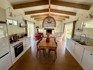 a kitchen with a wooden table and a kitchen with a stove at Jonkershuis Farm Retreat in Heidelberg