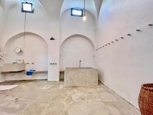 a room with white walls and arches and a table at Suite tolila te house of medina of tunis in Tunis