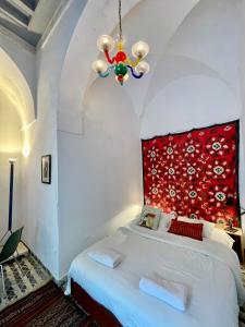 a bedroom with a large bed with a red headboard at Suite tolila te house of medina of tunis in Tunis