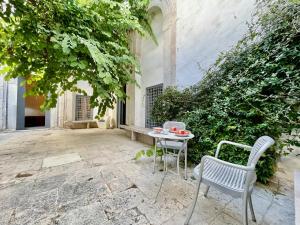 a patio with two chairs and a table at Suite tolila te house of medina of tunis in Tunis