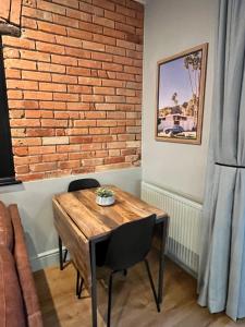 a dining room table with a brick wall at Beach Retreat, Stylish 1-Bed in Canford Cliffs in Canford Cliffs