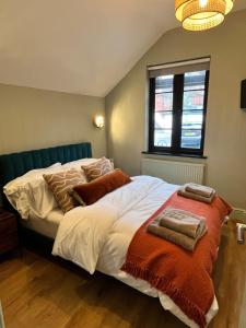 a bedroom with a large bed with towels on it at Beach Retreat, Stylish 1-Bed in Canford Cliffs in Canford Cliffs